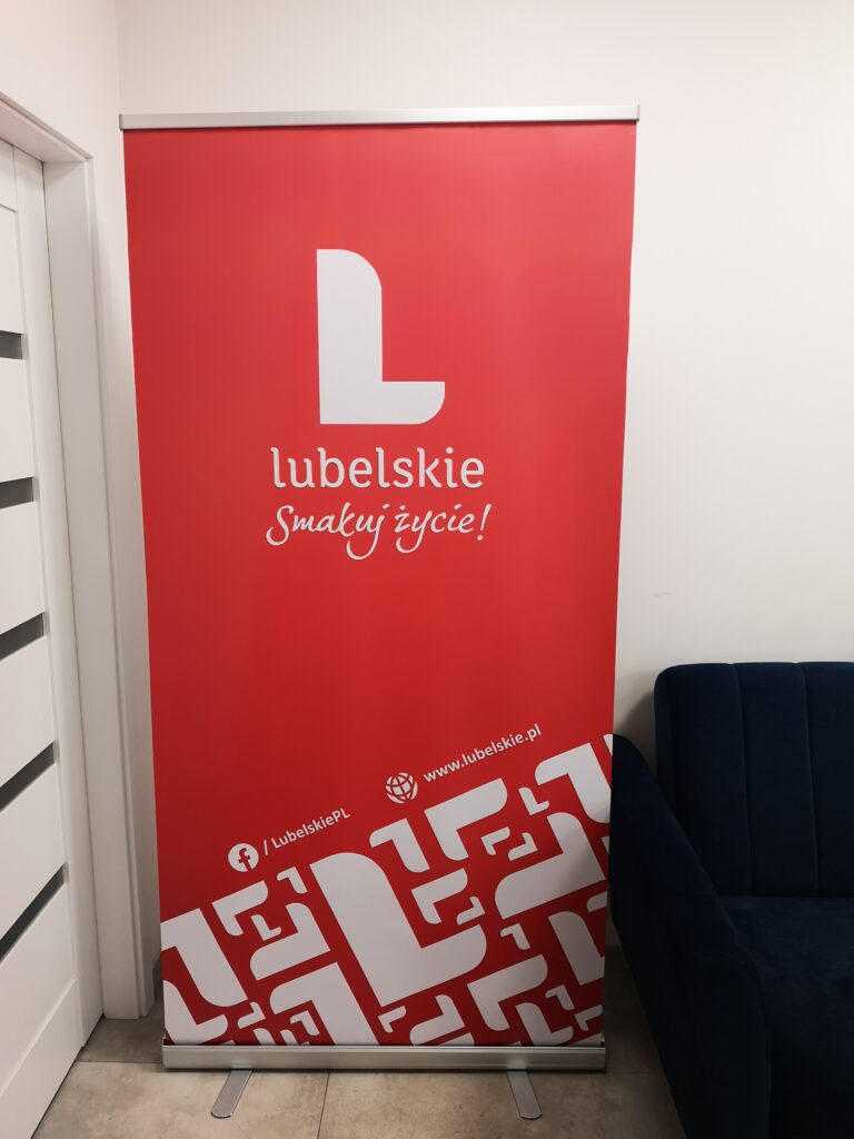 Roll-up reklamowy na stoisku targowym z widocznym logo marki